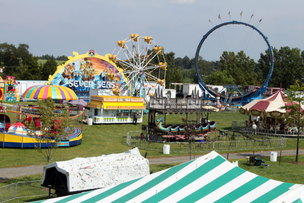 Several amusement rides, including a Ferris wheel and a carousel, at the Hunterdon County 4-H and Agricultural Fair